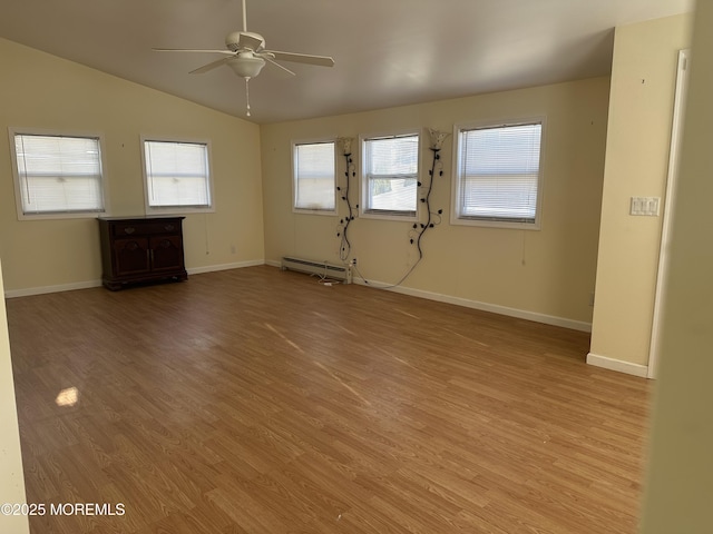 interior space featuring lofted ceiling, a baseboard heating unit, light wood finished floors, and ceiling fan