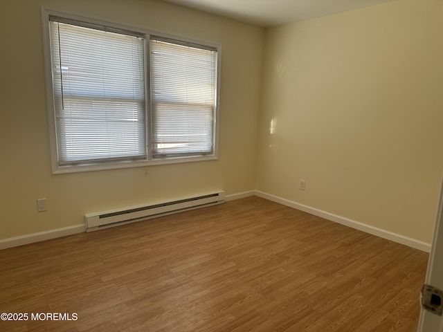 unfurnished room featuring light wood-style flooring, baseboards, and baseboard heating