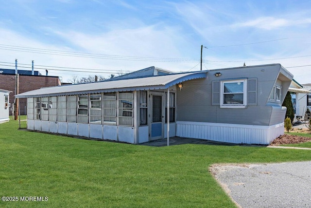 view of front of home featuring a sunroom and a front yard