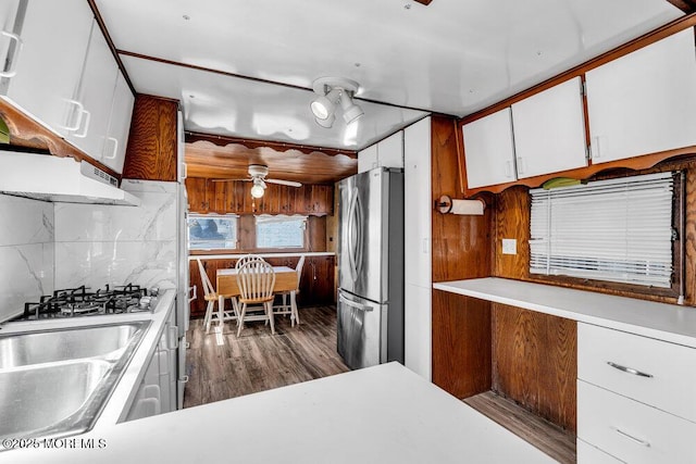 kitchen featuring stainless steel appliances, wood finished floors, white cabinets, light countertops, and tasteful backsplash