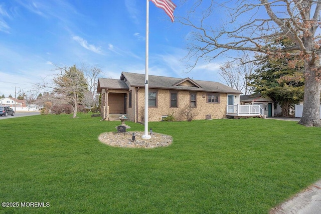 view of side of home with brick siding, a deck, and a yard