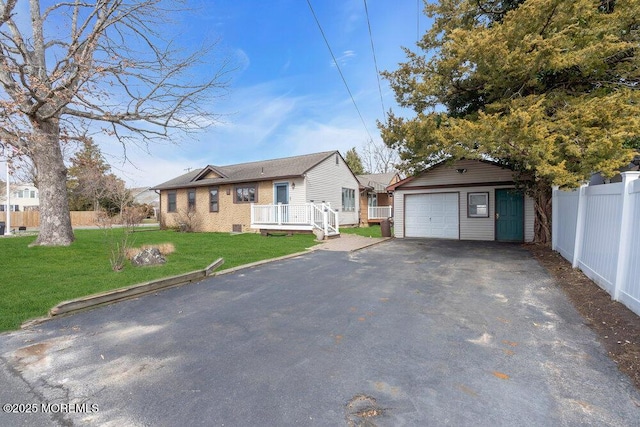 ranch-style house featuring an outbuilding, driveway, fence, a front yard, and a garage