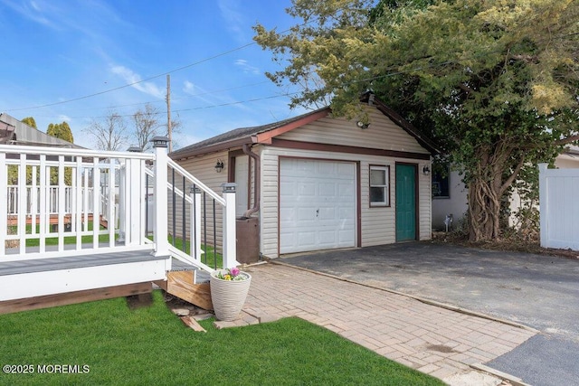 detached garage with aphalt driveway and fence