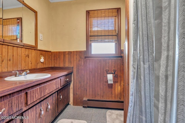 full bathroom featuring a baseboard heating unit, wooden walls, vanity, and wainscoting