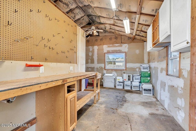 misc room featuring a workshop area, unfinished concrete floors, and vaulted ceiling