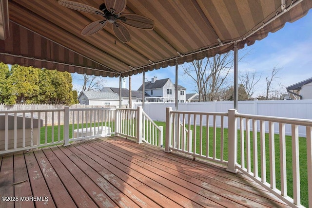 deck with a ceiling fan, a yard, and a fenced backyard