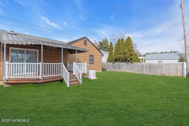 back of property with a yard, covered porch, cooling unit, and fence