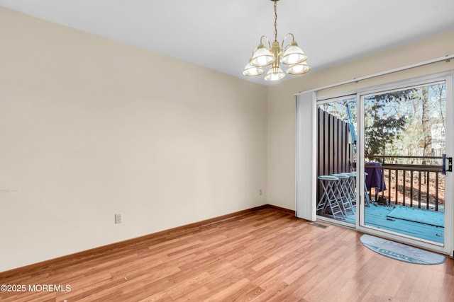 unfurnished room with a notable chandelier, baseboards, light wood-style floors, and visible vents