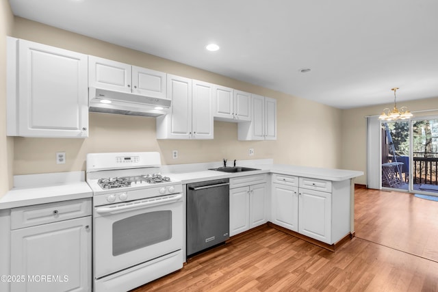 kitchen featuring a peninsula, white range with gas stovetop, a sink, under cabinet range hood, and dishwasher