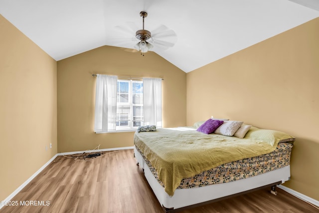 bedroom featuring wood finished floors, baseboards, and vaulted ceiling