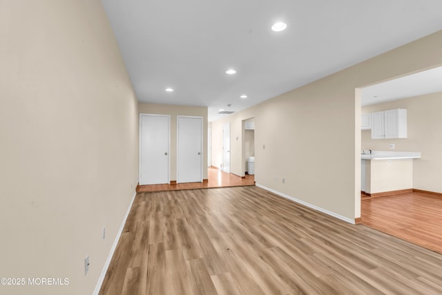 unfurnished room with recessed lighting, light wood-type flooring, baseboards, and visible vents