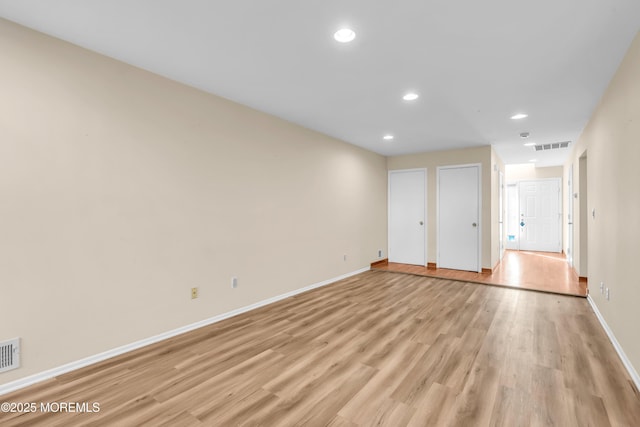 unfurnished room featuring recessed lighting, light wood-type flooring, baseboards, and visible vents