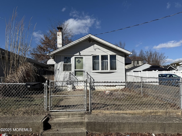 bungalow-style home featuring a fenced front yard, a chimney, and a gate