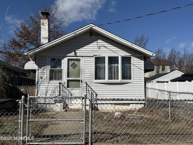 bungalow featuring a fenced front yard and a chimney