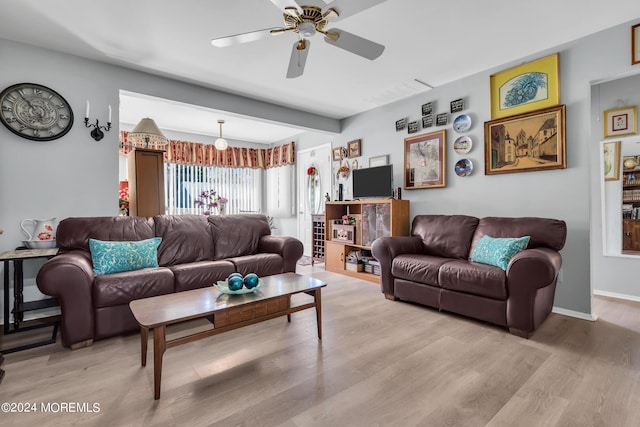 living area featuring baseboards, ceiling fan, visible vents, and light wood-style floors