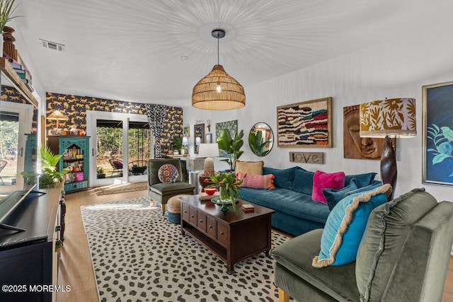 living area with a wealth of natural light, visible vents, and wood finished floors