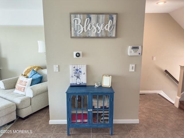 interior space featuring lofted ceiling, baseboards, and tile patterned floors