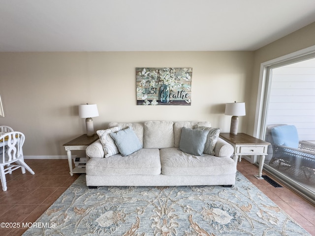 living area with baseboards and tile patterned floors