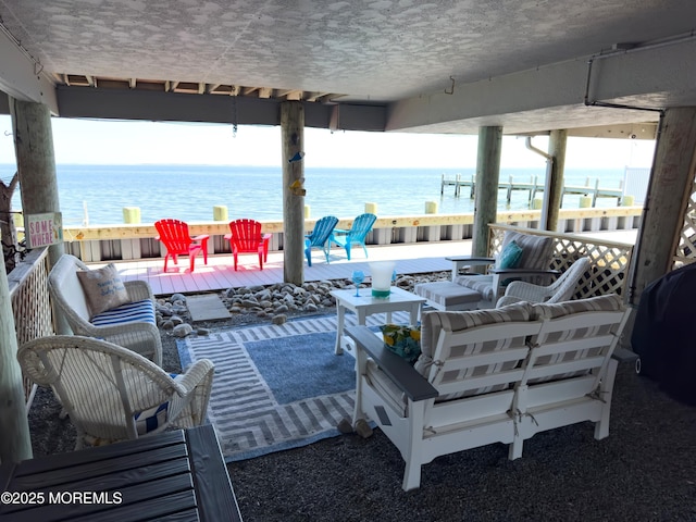 view of patio with an outdoor living space and a deck with water view