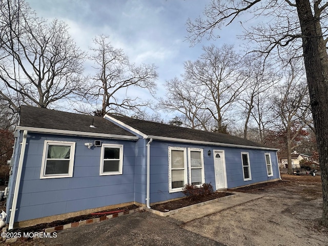 ranch-style house featuring roof with shingles