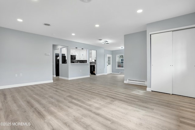 unfurnished living room featuring a baseboard heating unit, recessed lighting, visible vents, and light wood-style flooring