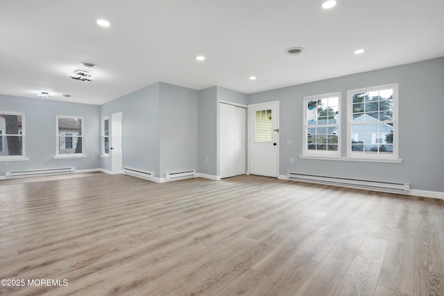 unfurnished living room featuring light wood finished floors, a baseboard radiator, and visible vents