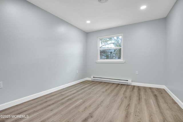 unfurnished room with baseboards, a baseboard heating unit, light wood-style flooring, and recessed lighting