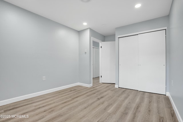 unfurnished bedroom with recessed lighting, a closet, light wood finished floors, and baseboards