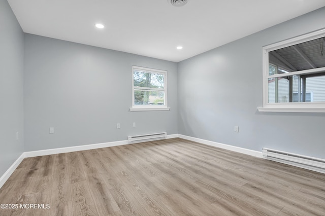 spare room with light wood-type flooring, baseboards, and baseboard heating