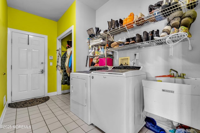 laundry room featuring laundry area, light tile patterned flooring, a sink, and washing machine and clothes dryer