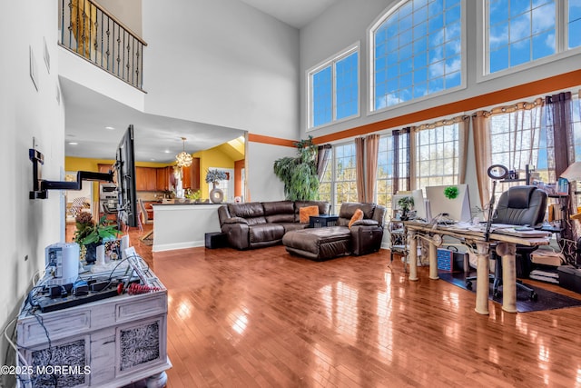 living area with a high ceiling, wood finished floors, and baseboards