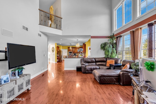 living room with light wood-style flooring, visible vents, and baseboards