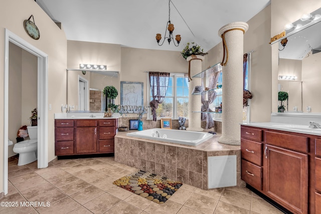 bathroom featuring two vanities, toilet, a sink, tile patterned flooring, and a bath