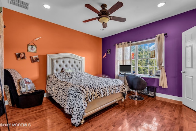 bedroom with baseboards, visible vents, wood finished floors, and recessed lighting