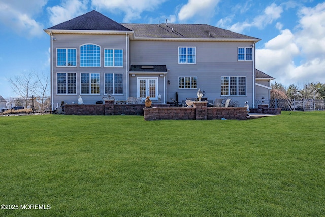 back of property featuring french doors, a yard, and fence