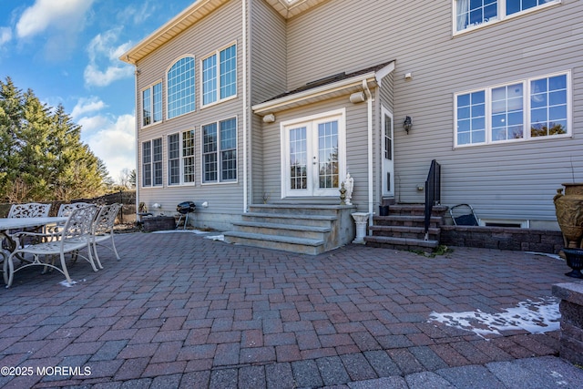 rear view of property featuring entry steps, a patio area, and french doors