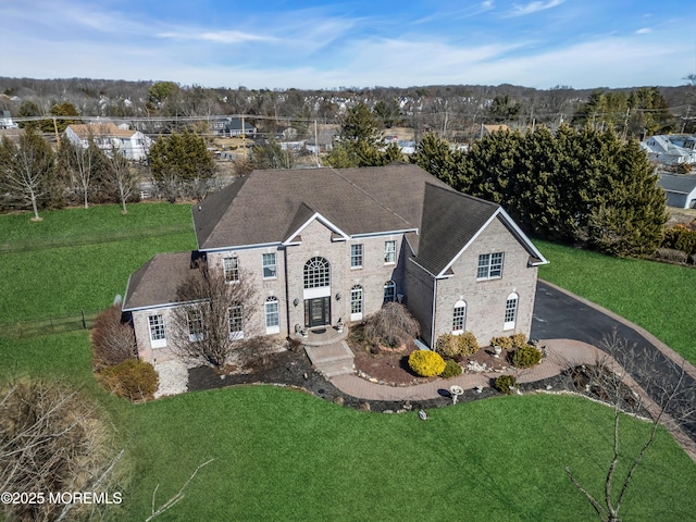 georgian-style home featuring aphalt driveway and a front yard