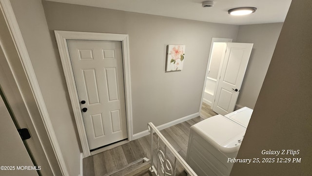 bedroom with light wood-style floors, baseboards, and washer and clothes dryer