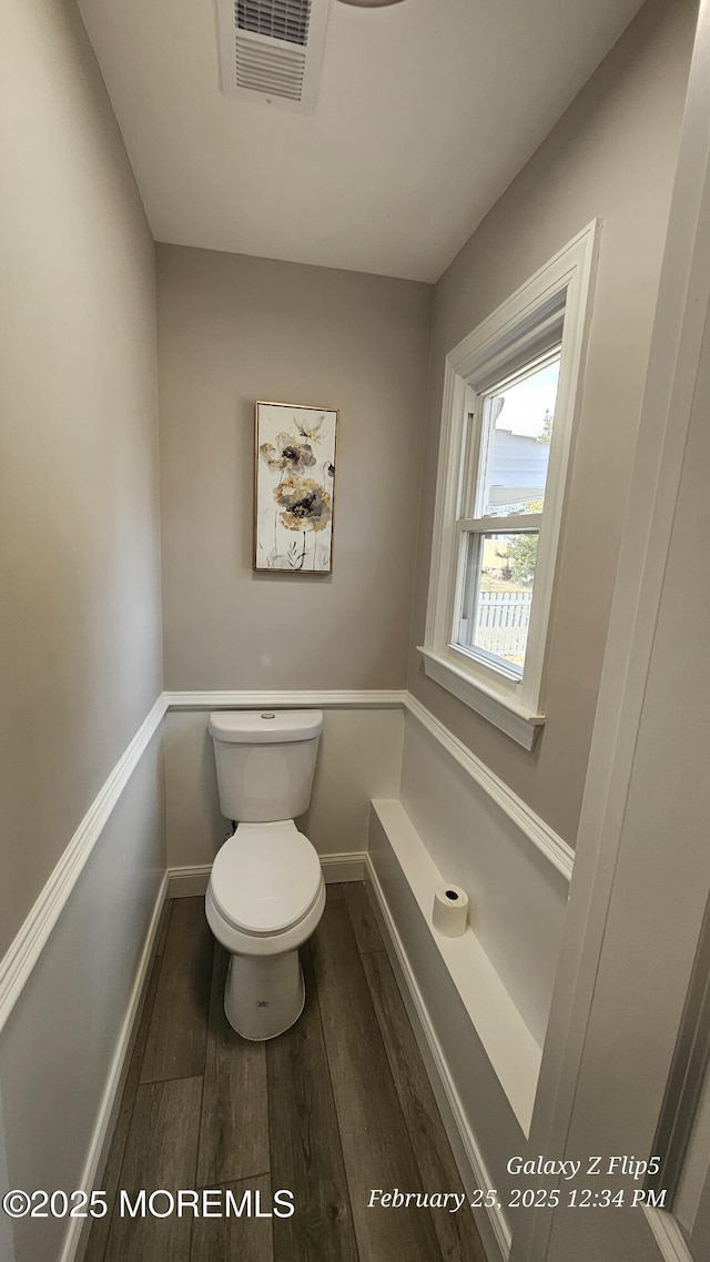 bathroom featuring toilet, baseboards, visible vents, and wood finished floors