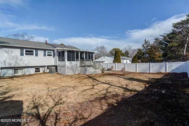 rear view of property featuring a sunroom, a fenced backyard, and central AC unit