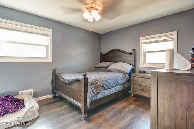 bedroom with dark wood-type flooring, visible vents, baseboards, and a ceiling fan