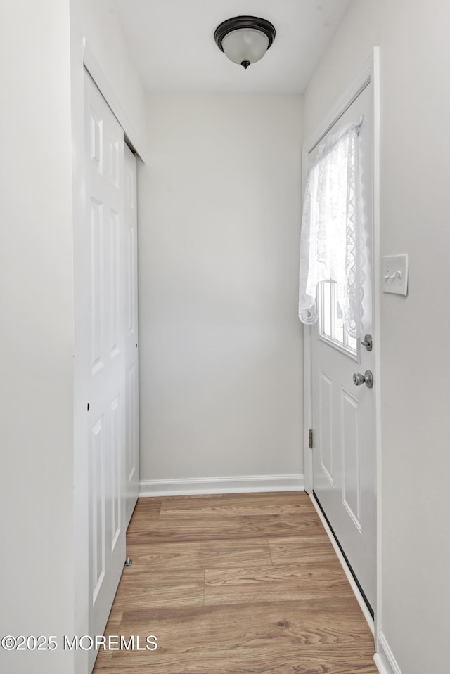 entryway with light wood-type flooring and baseboards