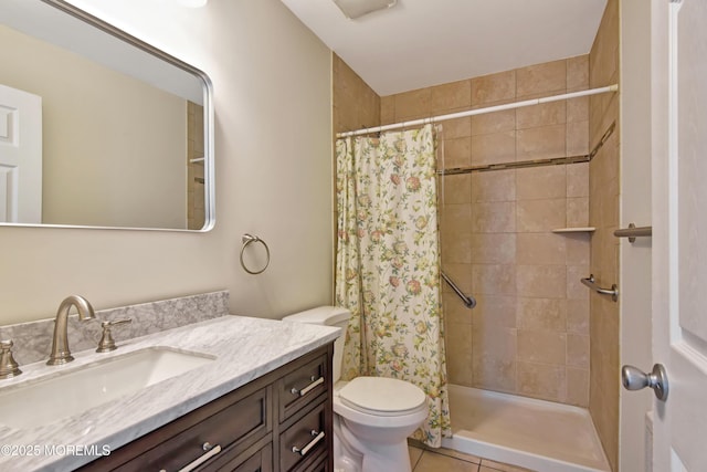 full bathroom featuring vanity, a tile shower, toilet, and tile patterned floors