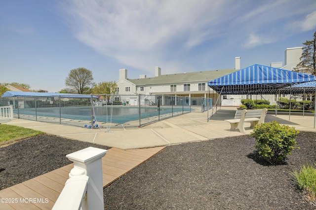 pool with a patio area and fence