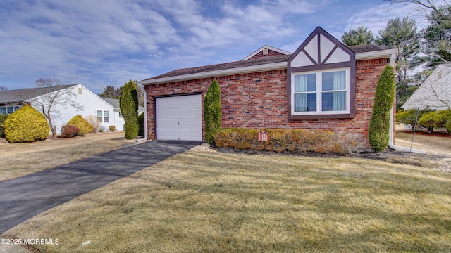 view of front facade with driveway, an attached garage, a front lawn, and brick siding