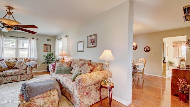 living area with visible vents, light wood-style flooring, and baseboards