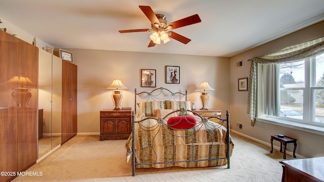 bedroom featuring light colored carpet, ceiling fan, visible vents, and baseboards