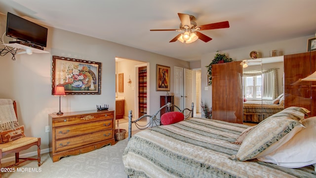 bedroom with a ceiling fan, carpet, baseboards, and connected bathroom