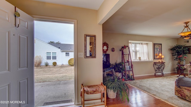 foyer with visible vents, ceiling fan, baseboards, and wood finished floors