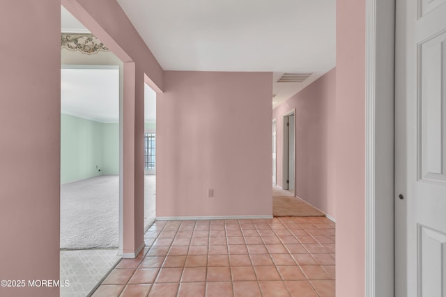 spare room with light carpet, light tile patterned floors, baseboards, and visible vents